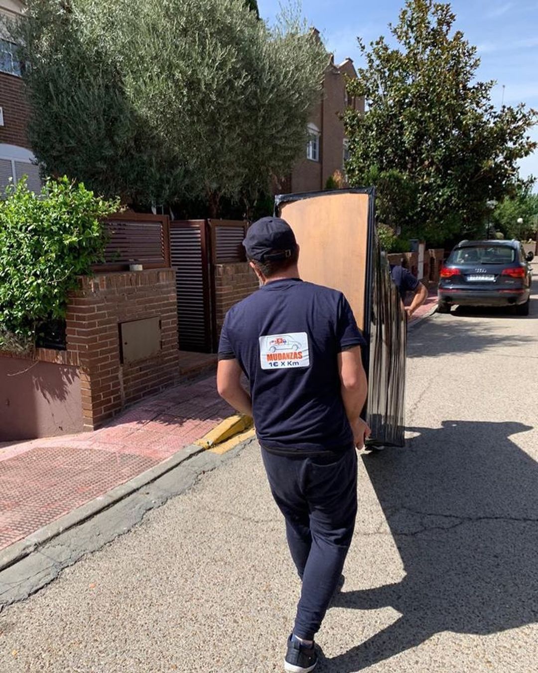 Dos personas cargando un mueble en la calle
