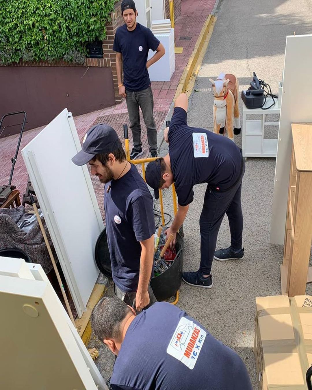 cuatros personas con partes de mueble alrededor en la calle